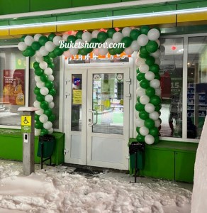 Арка из зелёных и белых шаров у входа в аптеку, праздничное оформление фасада, купить в Букет шаров Измайлово.