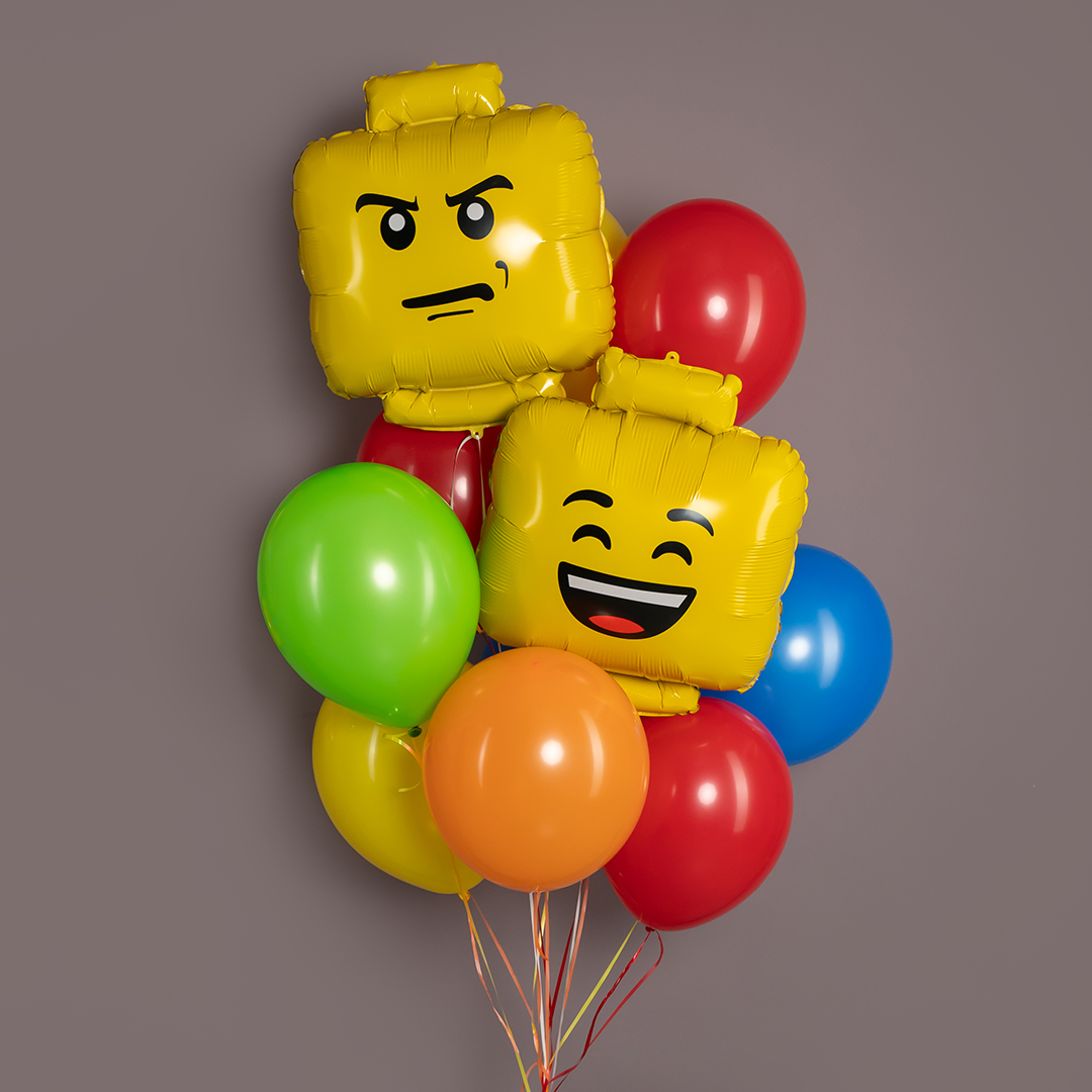 Воздушные шары с персонажами LEGO, окруженные красными, синими и зелеными шарами.