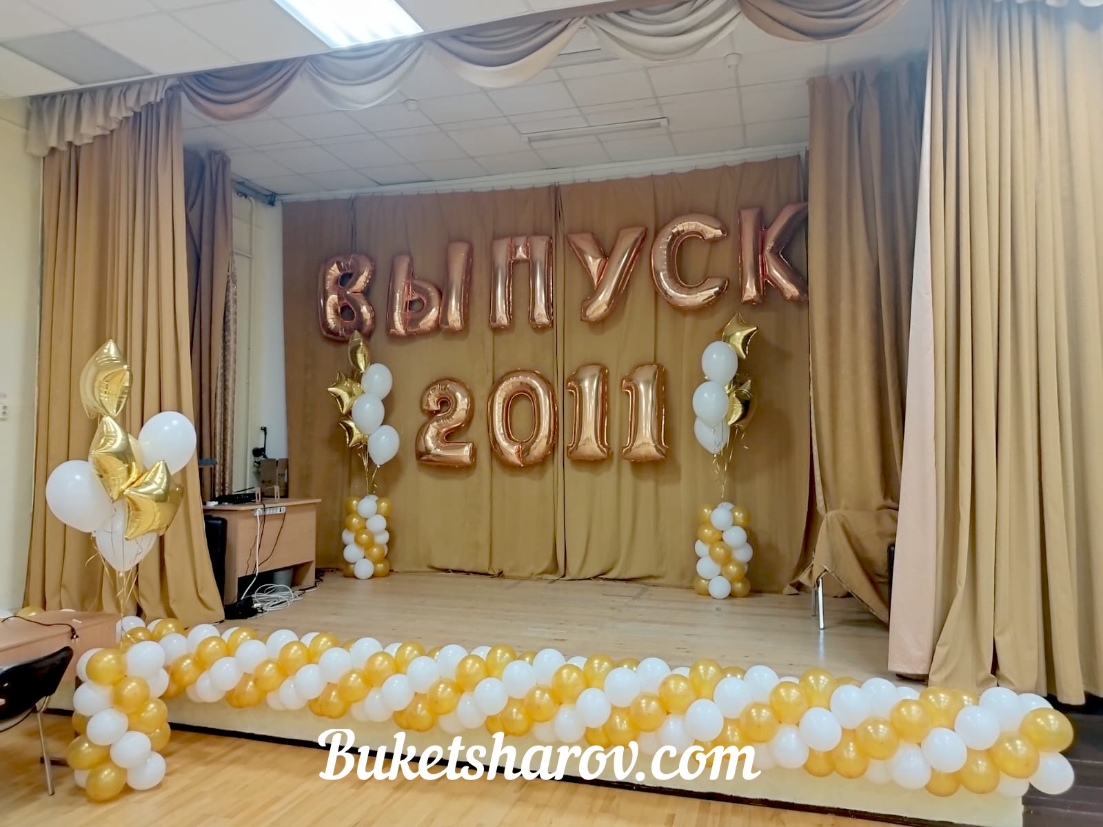 Бело-золотое оформление сцены для выпускного с большими цифрами и буквами, купить в Букет Шаров Измайлово для праздничного зала.